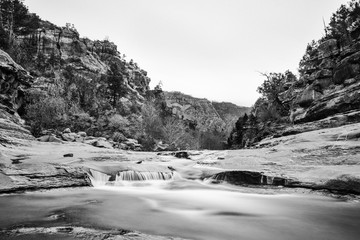 Black and white long exposure of a river flowing through rocks at Sliding Rock State Park in Arizona.