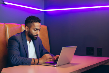 Young businessman working on laptop while sitting in office