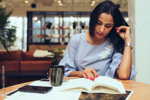 Businesswoman reading a book while sitting in office