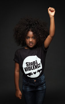 Portrait of girl standing against black background