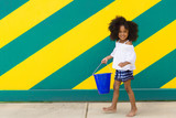 Portrait of smiling girl walking against wall