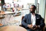 Businessman looking out through glass while sitting in cafe