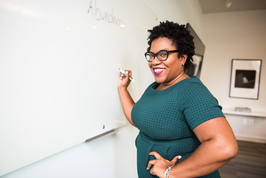 Smiling businesswoman writing on whiteboard