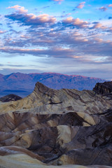 Sunrise begins to kiss the mountain sierra mountains in the background at Zabriskie Point in Death Valley California