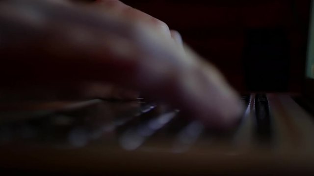User working on laptop computer at night - typing fast on illuminated keyboard - close up 4K UHD 23.976 fps stock footage