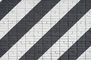 Diagonally painted bricks surface of wall in black and white color, as graffiti. Graphic grunge texture of wall. Abstract modern background