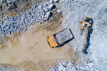 Truck and bulldozer working in the stone mine