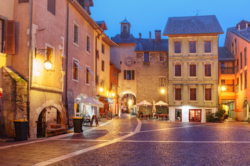 Fototapeta na wymiar Sainte-Claire gate with clock tower and Place Sainte-Claire in Old Town at rainy night, Annecy, France