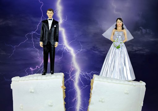 bride and groom figurine on split wedding cake with storm lightning background