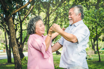 Fototapeta premium Happy elderly couple with lifestyle after retiree concept. Lovely asian seniors couple embracing together in the park in the morning.