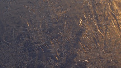 Snowflakes on the window in supermacro shooting. They are highlighted by the sunset. Real real snowflakes shot very close.
