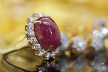 Vintage red ruby jewelry golden ring on black reflection background
