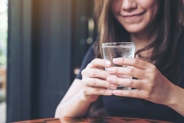 Closeup image of woman holding a glass of cold water to drink