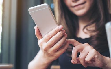 Closeup image of a woman holding , using and looking at smart phone
