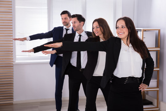 Businesspeople Doing Exercise With Hands Outstretched