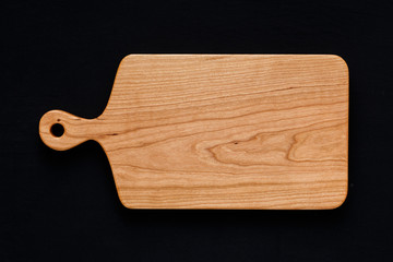 Handmade cherry wood chopping board on black cotton cloth