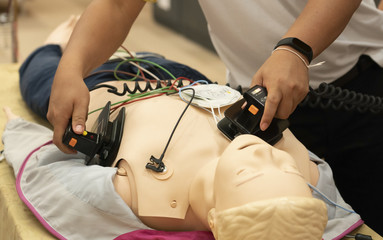 A male trainee performing defibrillation with a model on ACLS training course