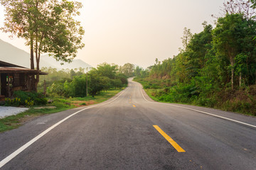 Obraz premium Curve Asphalt Road Through Green Forest On The Mountains, Thailand.