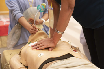 Obraz na płótnie Canvas A trainee perform chest compression with another nurse ventilate by ambubag via endotracheal tube on a mannequin