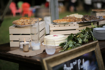 Wedding Dessert Bar with Cookies, Cakes, and Pies Rustic Wedding Decor Pink, Peach, Purple, and Green Floral Centerpieces on a Wooden Farm Table