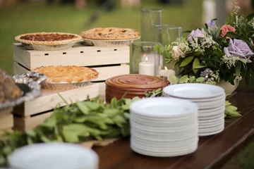 Wedding Dessert Bar with Cookies, Cakes, and Pies Rustic Wedding Decor Pink, Peach, Purple, and Green Floral Centerpieces on a Wooden Farm Table © holly
