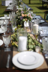 Rustic Wedding Decor Pink, Peach, Purple, and Green Floral Centerpieces on a Wooden Farm Table