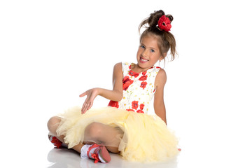 Little girl is sitting on the floor.