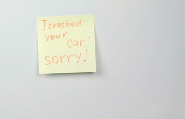 Note on yellow sticker paper sheets with words i crashed your car sorry.