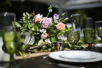 Obraz na płótnie Canvas Rustic Wedding Decor Pink, Peach, Purple, and Green Floral Centerpieces on a Wooden Farm Table