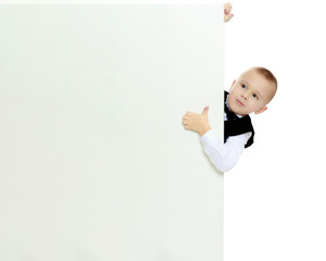 boy peeks out from behind the banner