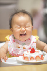 Fototapeta premium 1歳の誕生日ケーキを食べる子供