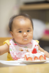 1歳の誕生日ケーキを食べる子供