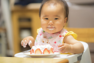 1歳の誕生日ケーキを食べる子供