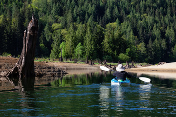 Kayaking during a vibrant morning surrounded by the Canadian Mountain Landscape. Taken in Stave Lake, East of Vancouver, British Columbia, Canada. Concept: Adventure, vacation, holiday