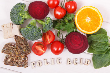 Inscription folic acid with nutritious ingredients containing vitamin B9, natural minerals and folic acid, healthy nutrition concept