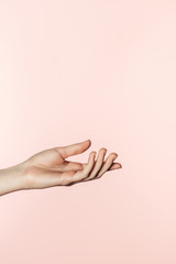 partial view of woman gesturing by hand isolated on pink background