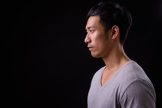 Young Handsome Asian Man Against Black Background