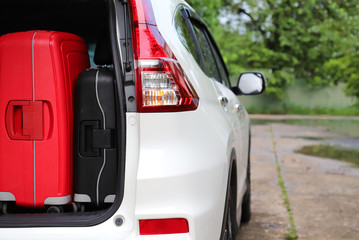 Closeup of right rear side of white car carry suitcases for  lovely family holiday in summer .