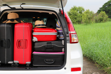 Closeup of rear side of white car carry suitcases and other things for lovely family holiday in summer.