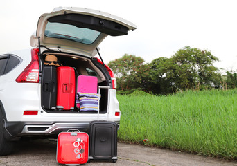 Closeup of rear side of white car carry suitcases and other things for lovely family holiday in summer.
