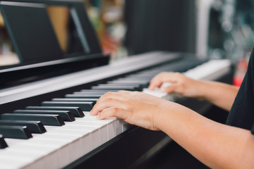 An asian boys  playing the piano.