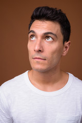 Young handsome Hispanic man against brown background