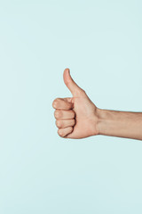 cropped image of man doing thumb up gesture isolated on blue background