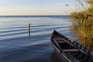 Old boat on the lake at sunrise, romania