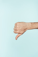 cropped shot of man doing thumb down gesture isolated on blue background
