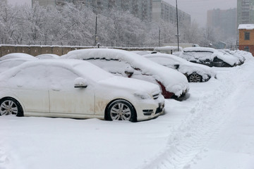 MOSCOW, FEB. 04, 2018: Winter view on cars under snow. Snow covered the cars and they can not move. Dangerous trees under heavy snow. Snow storm on city street