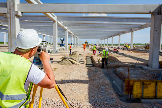 Civil engineer, geodesist is working with total station on a building site