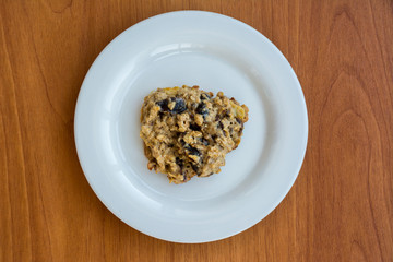 Homemade oatmeal cookies on plate on the wooden table.