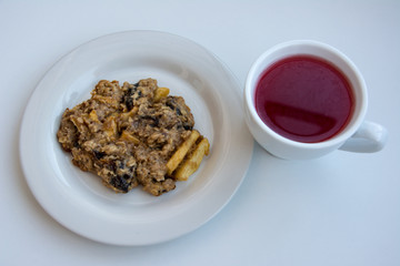 Homemade oatmeal cookies on plate with cap of cranberry compote on the white background.