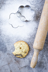 Homemade oatmeal cookies with chocolate chips on a gray kitchen table among accessories for baking....